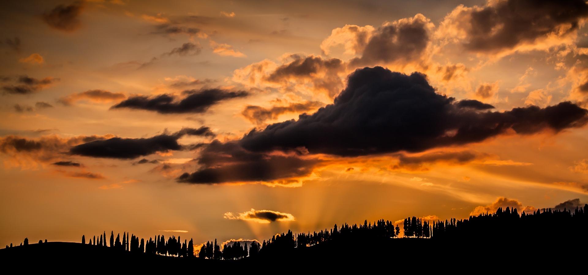 Paesaggi Tramonto con Raggi di Sole Oltre la Collina su Cielo Rosso